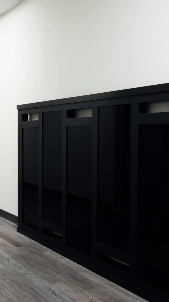 Black glass sliding gate sample with vertical panels at the All Glass showroom