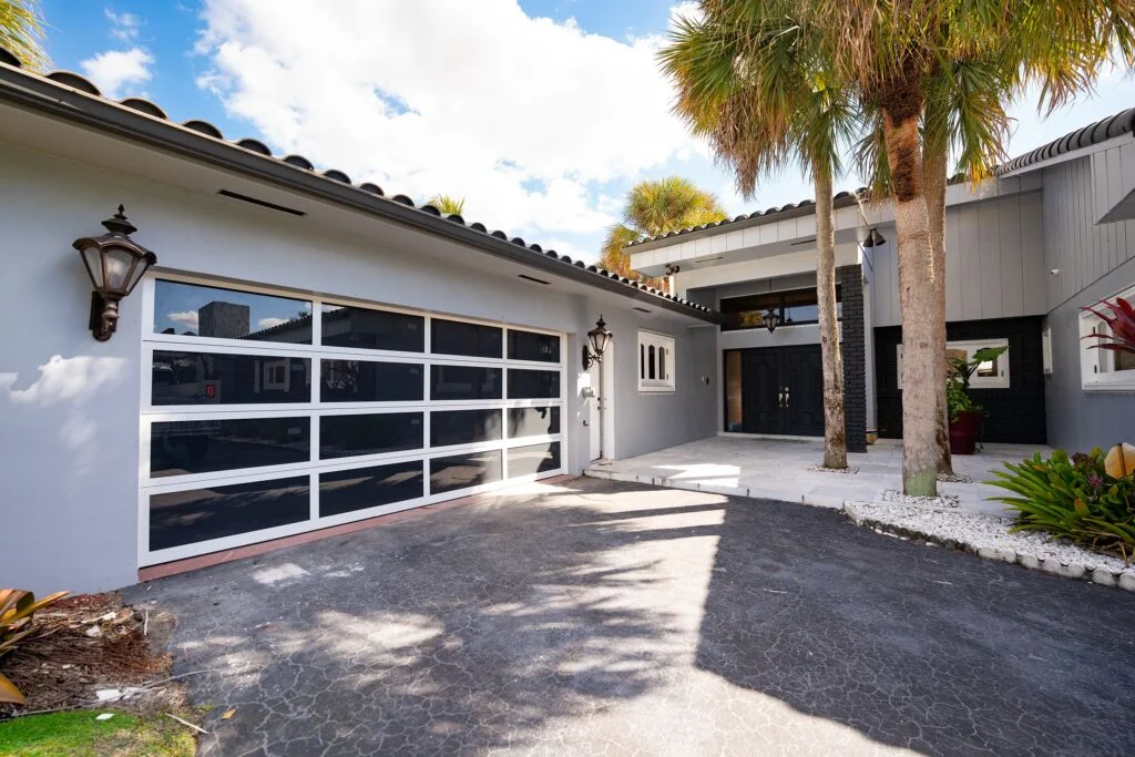 Dubai Framed glass garage door with white frames on a Florida home with palm trees