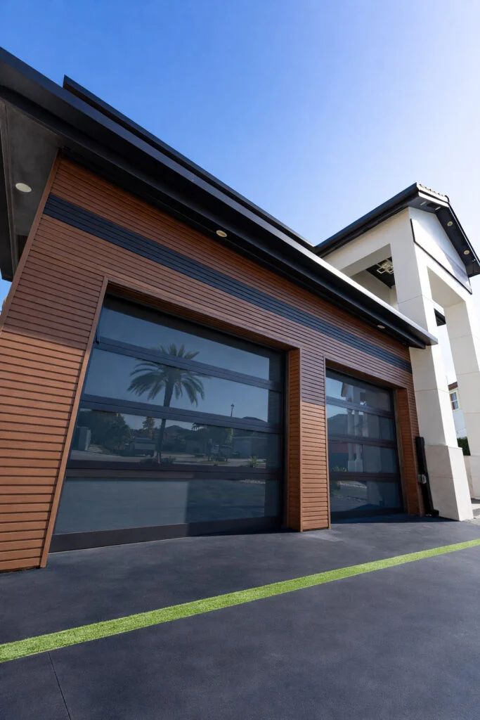 Dubai Framed aluminum-and-glass garage doors with wood-look framing on a modern home