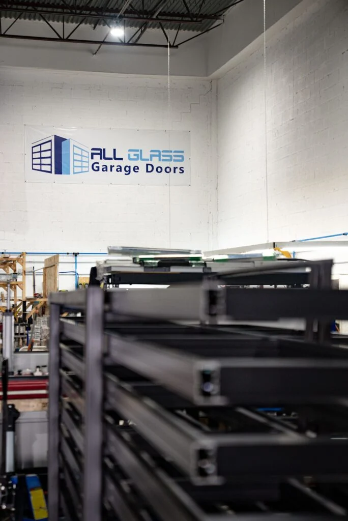 Finished aluminum garage door sections stacked in the All Glass factory