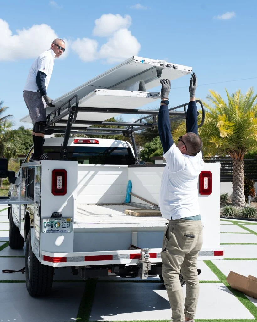 All Glass crew unloading glass garage door sections from a truck