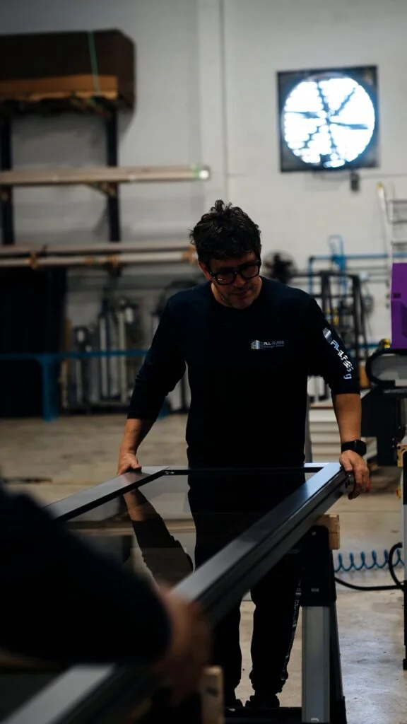 All Glass technician assembling an aluminum sliding gate frame in the Doral factory